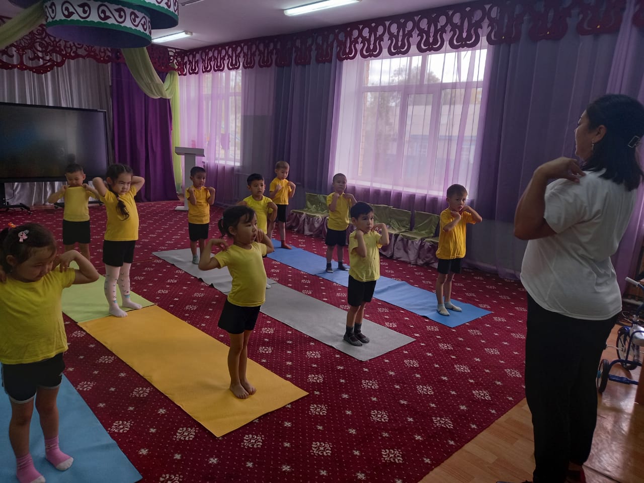 Таңғы жаттығулар.Мақсаты:денені шынықтырудың маңыздылығын түсіндіру.Дене жаттығуларын белсенді орындайды,таңертеңгі жаттығуларды жасауға дағдыландыру."Күншуақ" МАД тобы.Денешынықтыру нұсқаушы